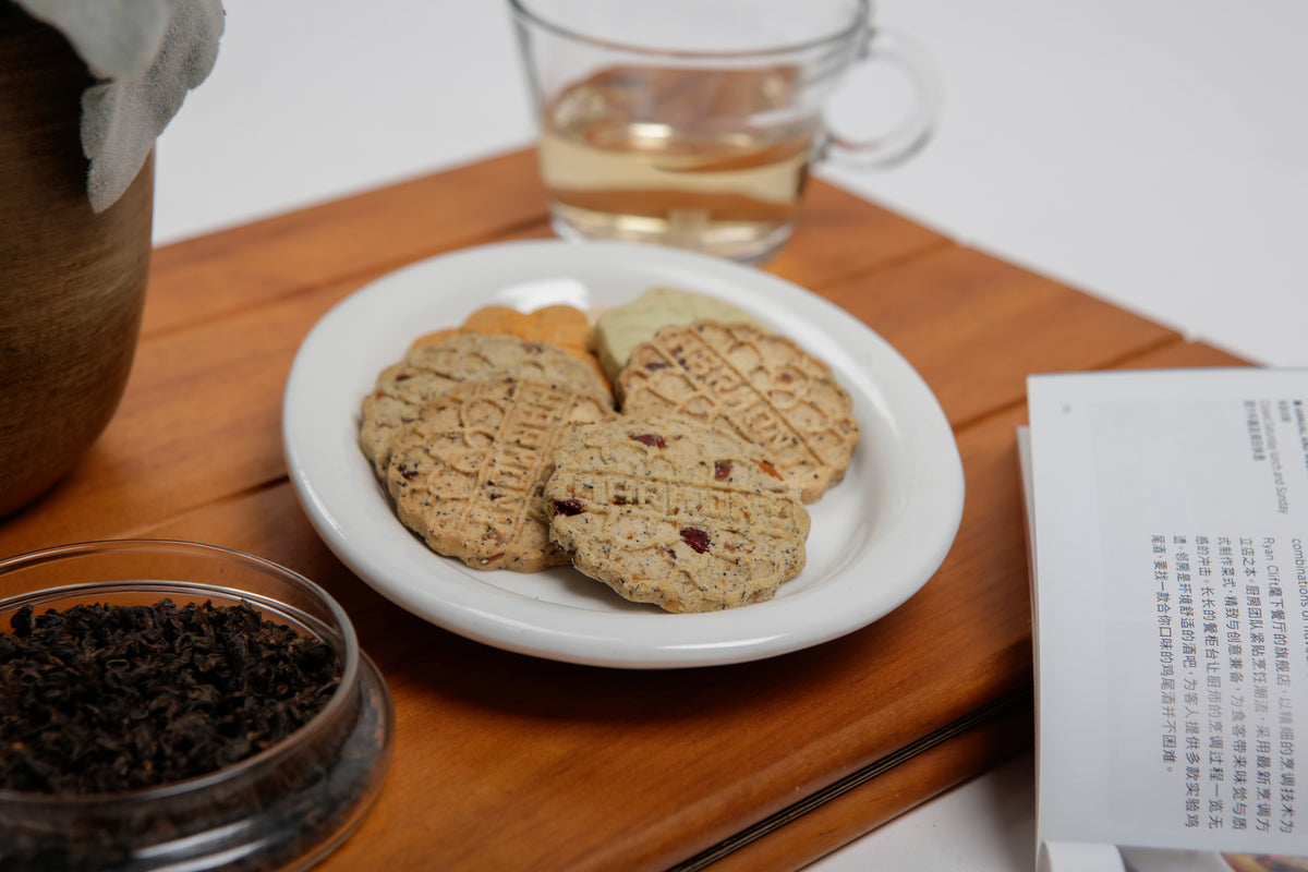 A plate of Harmony cookies beside a glass of tea